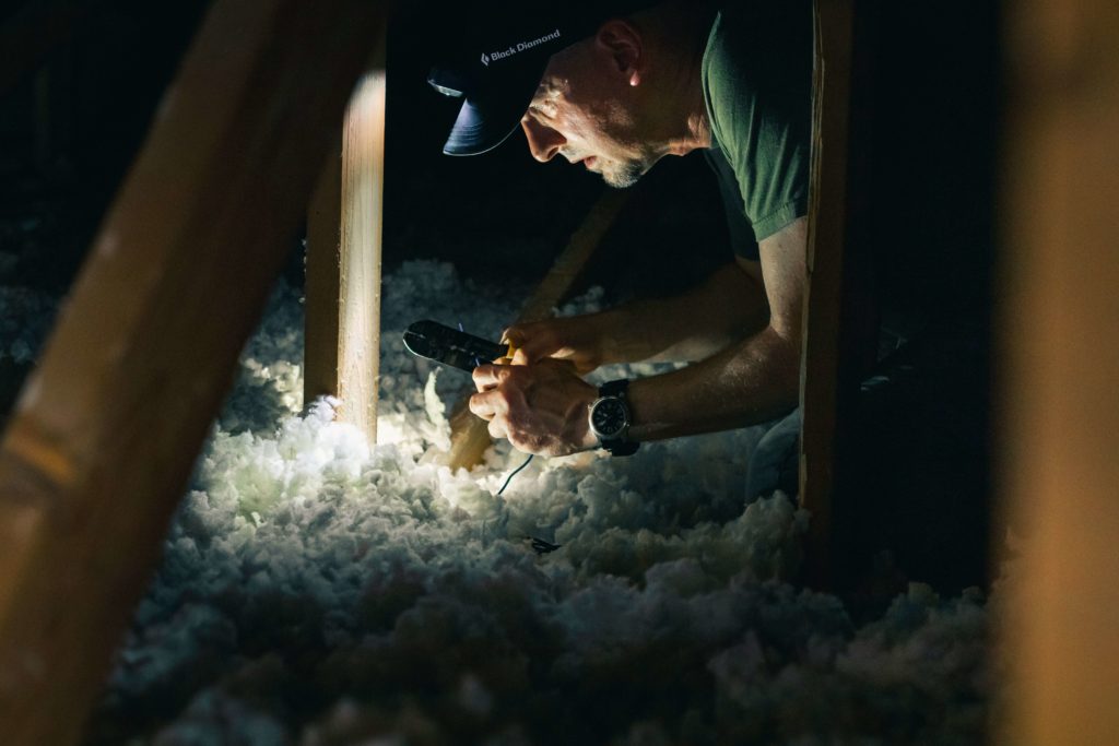 homme isolant le plafond d'une maison