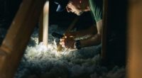 homme isolant le plafond d'une maison